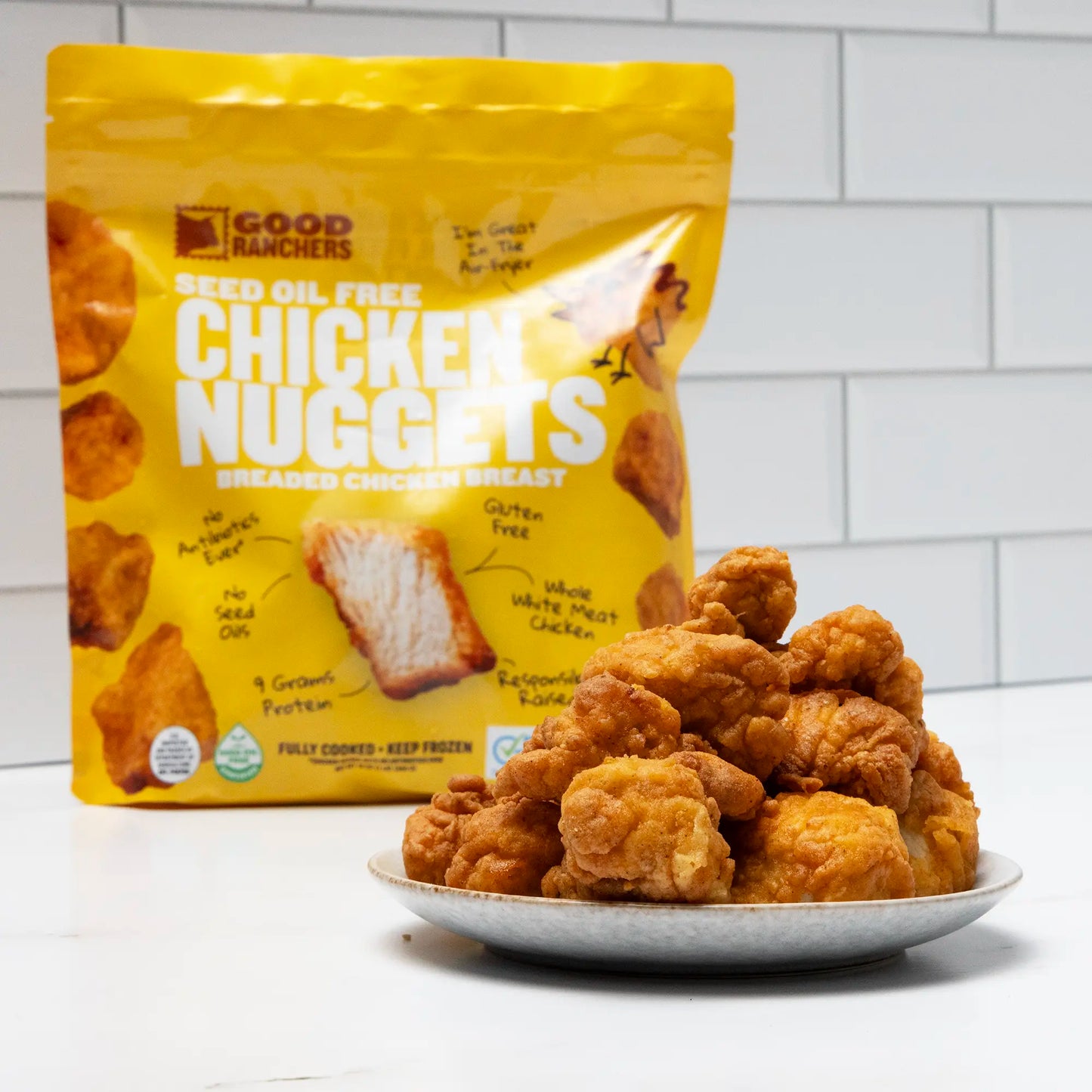 Seed Oil Free Chicken Nuggets Single Bag On Counter With Plate of Nuggets